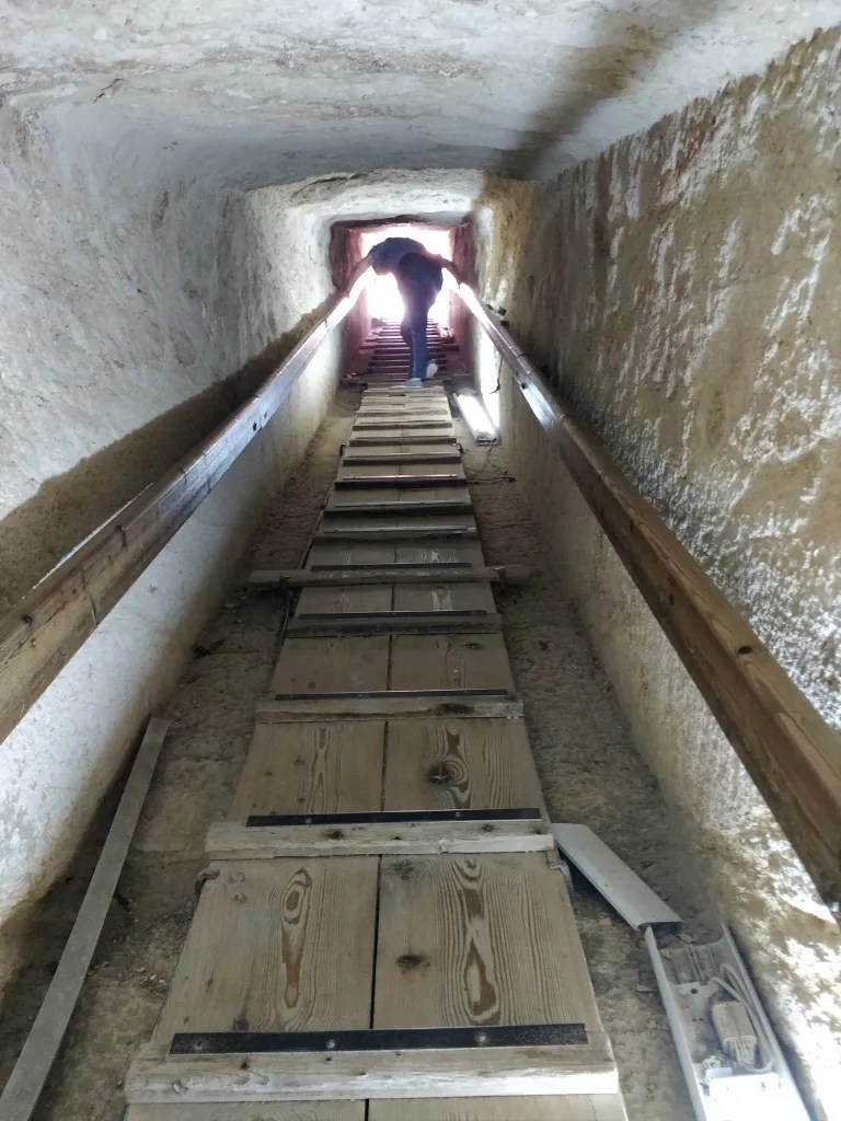 climbing up steps to go out of the pyramid